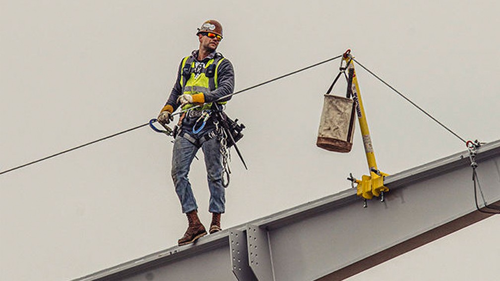 Steeplejack sitting on a construction on the top.